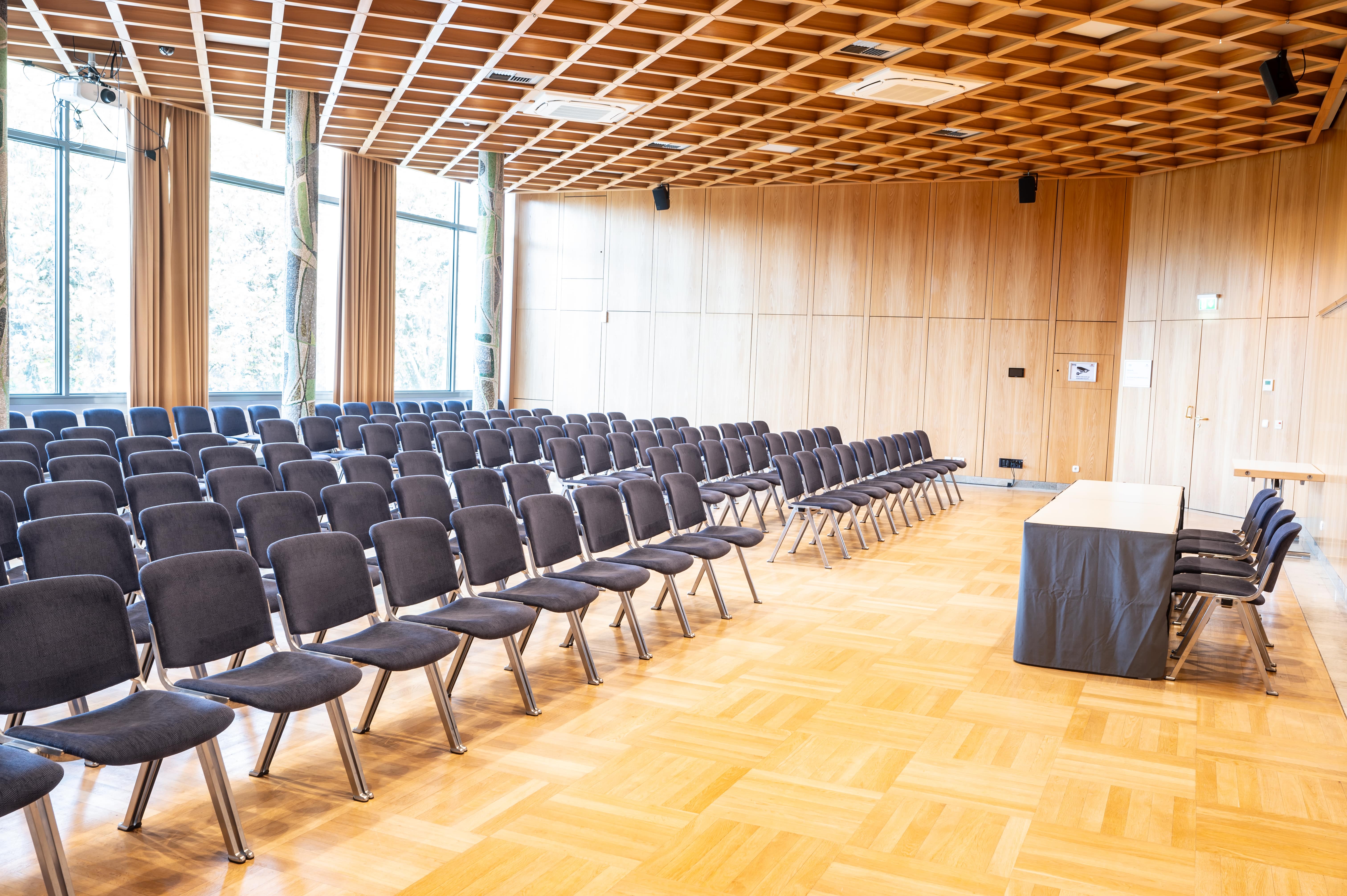 Märklinsaal mit Konferenzbestuhlung mit Tischreihen Sicht auf die Leinwand